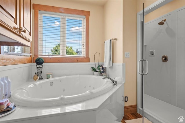 bathroom featuring a stall shower and a tub with jets