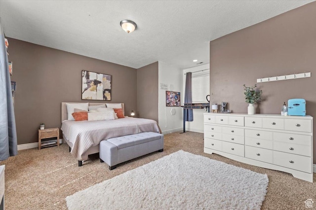 bedroom featuring a textured ceiling, light colored carpet, and baseboards
