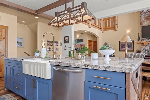 kitchen featuring a sink, open floor plan, dark wood finished floors, beam ceiling, and stainless steel dishwasher