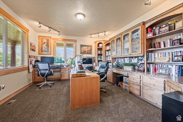 home office with visible vents, baseboards, track lighting, dark colored carpet, and a textured ceiling