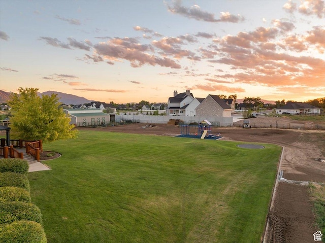 view of yard featuring fence, a residential view, and a playground
