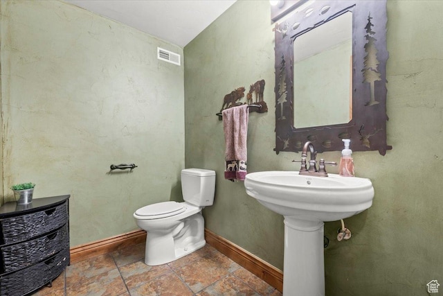 half bath with visible vents, toilet, and baseboards