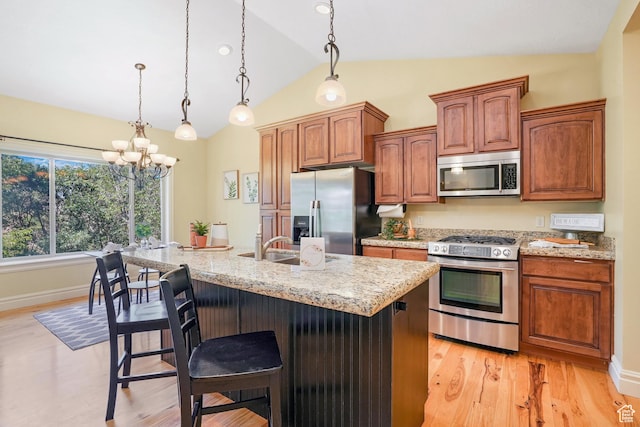 1429 E Chateau Ridge Way S, Sandy, UT 84092 - kitchen featuring stainless steel appliances, a breakfast bar, hanging light fixtures, and an island with sink