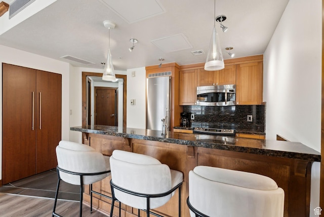 3720 N Sundial Ct Unit C207, Park City, UT 84098 - kitchen with stainless steel appliances, backsplash, a breakfast bar, and pendant lighting