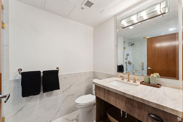3720 N Sundial Ct Unit C207, Park City, UT 84098 - bathroom featuring a shower, toilet, vanity, tile walls, and a wainscoted wall