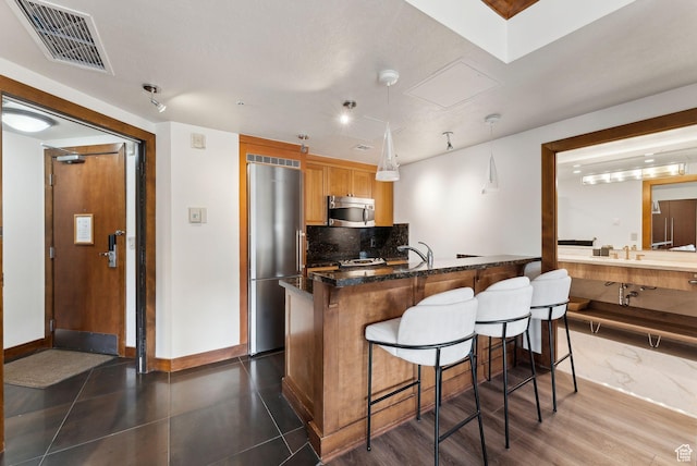 3720 N Sundial Ct Unit C207, Park City, UT 84098 - kitchen with appliances with stainless steel finishes, a kitchen breakfast bar, decorative backsplash, baseboards, and a sink