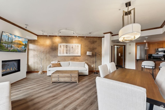 3720 N Sundial Ct Unit C207, Park City, UT 84098 - dining room featuring ornamental molding, rail lighting, baseboards, light wood-style flooring, and a glass covered fireplace