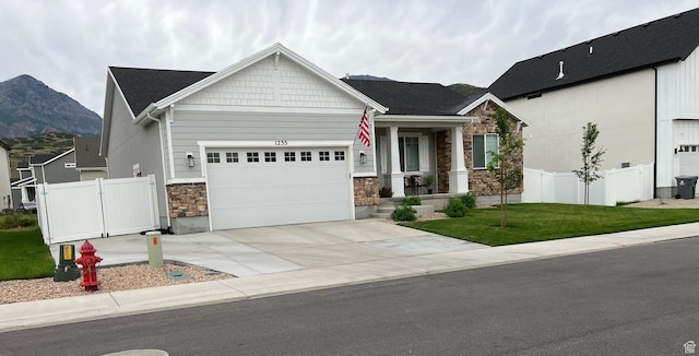 1255 S Raintree Ln, Santaquin, UT 84655 - craftsman inspired home with stone siding, an attached garage, concrete driveway, a mountain view, and covered porch