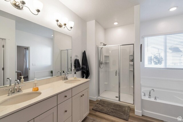 bathroom featuring wood finished floors, a stall shower, a sink, and a bath