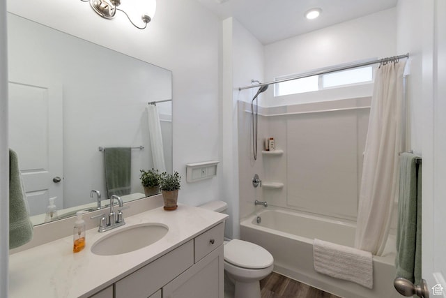 bathroom featuring toilet, shower / tub combo, wood finished floors, and vanity