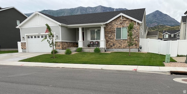 1255 S Raintree Ln, Santaquin, UT 84655 - craftsman-style home with stone siding, a mountain view, a garage, concrete driveway, and covered porch