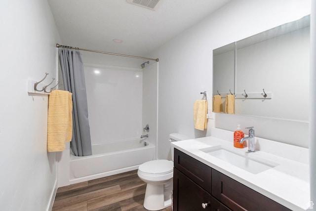 full bath featuring visible vents, toilet, shower / bath combo with shower curtain, vanity, and wood finished floors