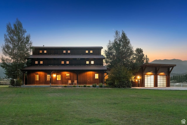 703 River Rd, Midway, UT 84049 - back of property at dusk featuring a lawn, covered porch, and a mountain view