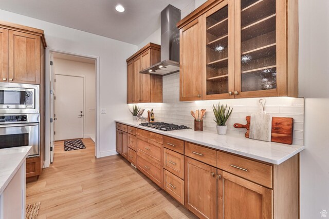 38 S 1840 W, St George, UT 84770 - kitchen featuring wall chimney range hood, brown cabinetry, glass insert cabinets, and appliances with stainless steel finishes
