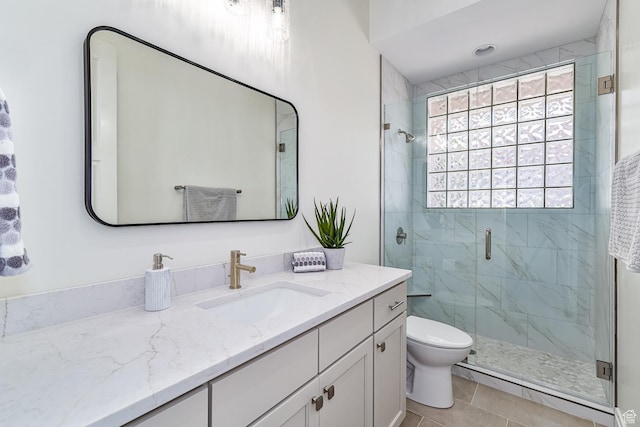 bathroom featuring toilet, tile patterned flooring, a shower stall, and vanity