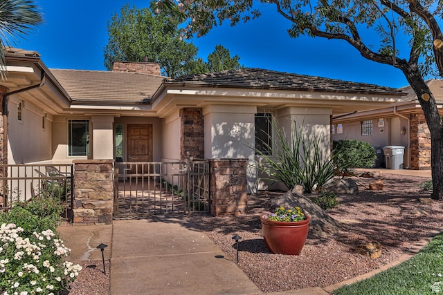 ranch-style house with a chimney, stucco siding, a gate, fence, and stone siding