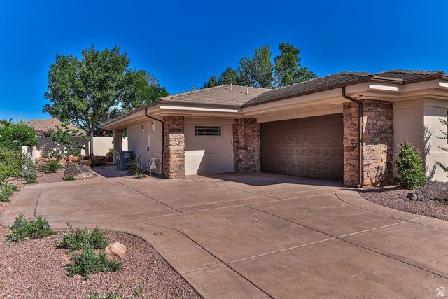 38 S 1840 W, St George, UT 84770 - view of home's exterior with a garage, concrete driveway, stone siding, a tiled roof, and stucco siding