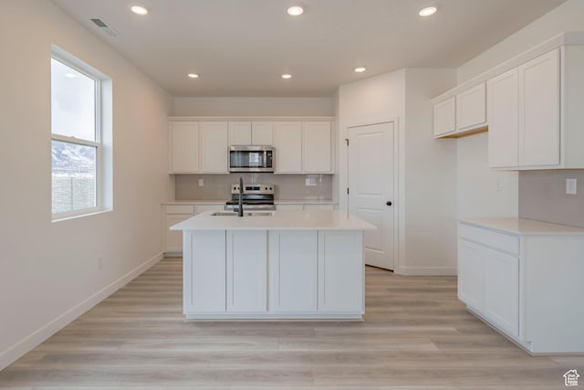 1686 N 800 W, Salem, UT 84653 - kitchen featuring appliances with stainless steel finishes, a center island with sink, white cabinets, tasteful backsplash, and recessed lighting