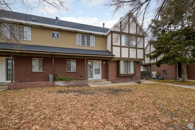view of front facade with brick siding and a shingled roof