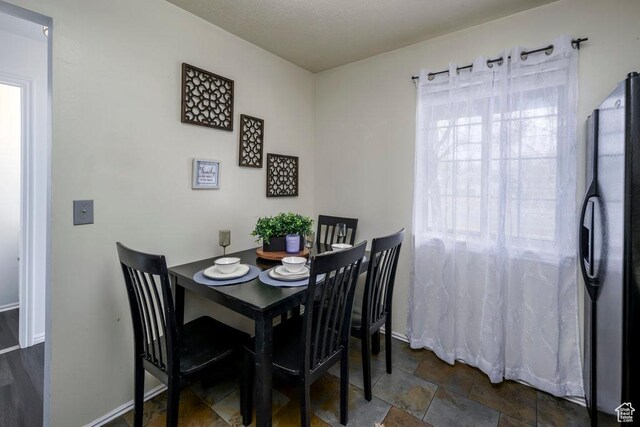 488 E 200 S Unit A3, Clearfield, UT 84015 - dining space with a healthy amount of sunlight, baseboards, and stone finish floor