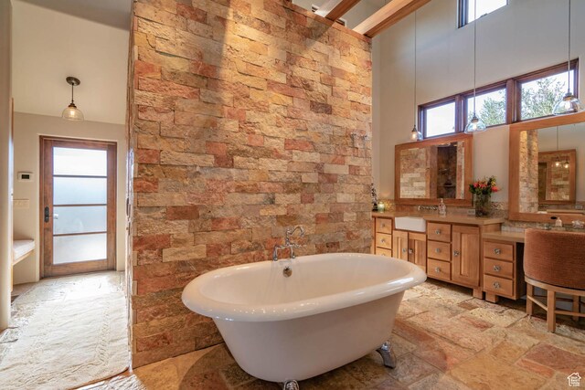 1558 N Harvard Ave, Washington, UT 84780 - full bath with a freestanding tub, stone tile floors, a high ceiling, a sink, and double vanity