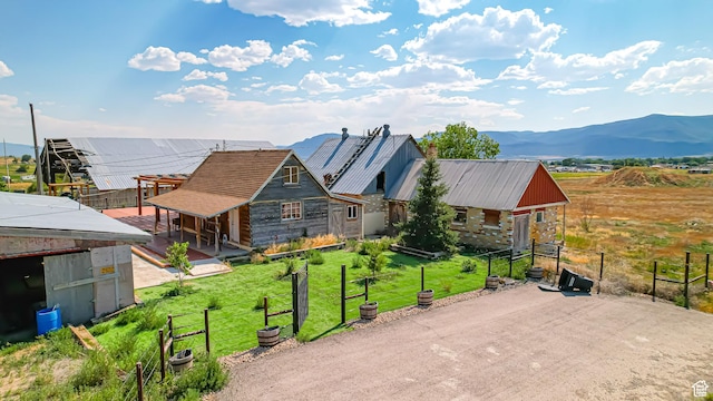 view of front of property with dirt driveway, an outbuilding, and a mountain view