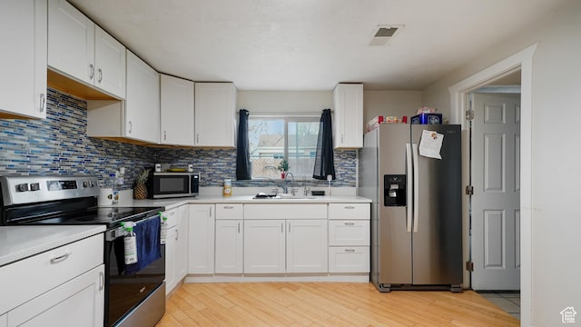 2812 S 9150 W, Magna, UT 84044 - kitchen featuring white cabinets, appliances with stainless steel finishes, light countertops, and a sink