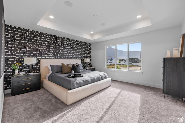 2452 W 2950 N Unit 112, Farr West, UT 84404 - bedroom featuring an accent wall, a tray ceiling, wallpapered walls, and baseboards