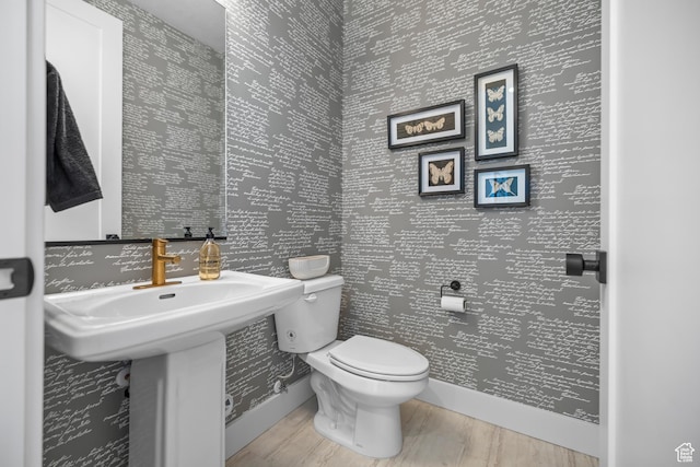 2452 W 2950 N Unit 112, Farr West, UT 84404 - half bathroom with toilet, wallpapered walls, baseboards, and wood finished floors