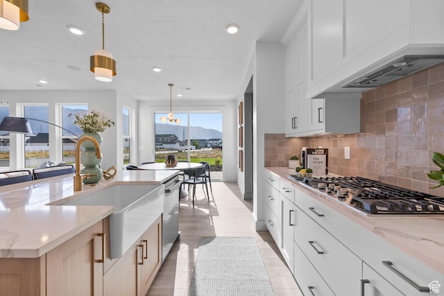 2452 W 2950 N Unit 112, Farr West, UT 84404 - kitchen with appliances with stainless steel finishes, pendant lighting, white cabinetry, and light stone countertops