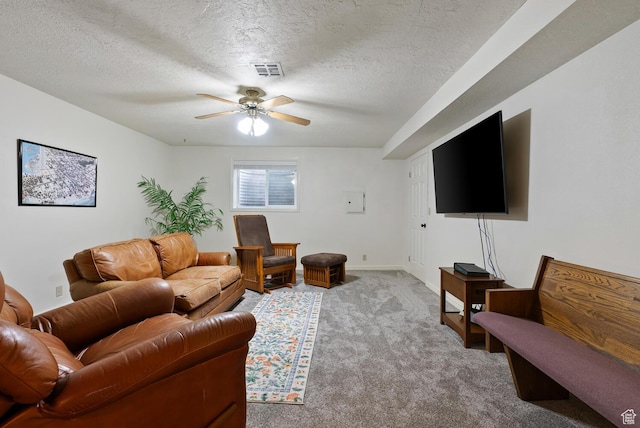 living room featuring visible vents, light carpet, ceiling fan, a textured ceiling, and baseboards