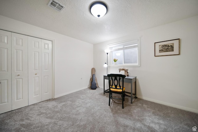 home office with baseboards, visible vents, a textured ceiling, and light colored carpet