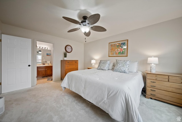 bedroom with light carpet, ceiling fan, a sink, and ensuite bathroom
