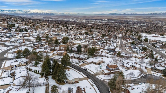 snowy aerial view with a residential view and a mountain view