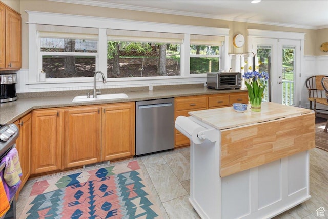 kitchen with a sink, ornamental molding, a wealth of natural light, and stainless steel appliances