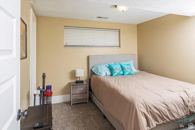 bedroom with dark colored carpet, visible vents, and baseboards
