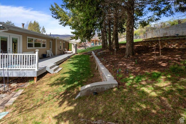 view of yard featuring french doors, fence, and a wooden deck