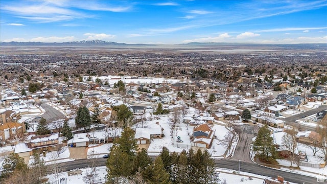 snowy aerial view featuring a mountain view and a residential view