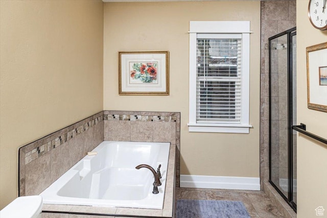bathroom with toilet, a bath, a shower stall, and baseboards