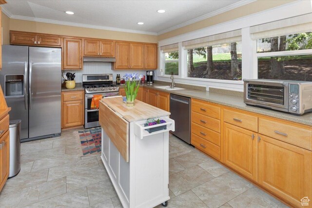 kitchen featuring crown molding, under cabinet range hood, a sink, stainless steel appliances, and a toaster