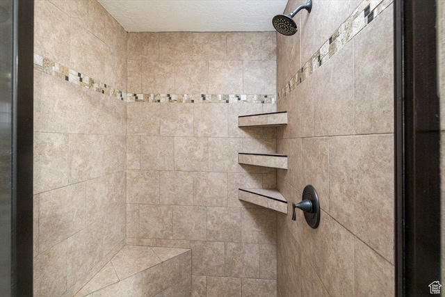 full bath featuring a tile shower and a textured ceiling