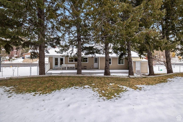 view of front of house with a patio area, french doors, and fence