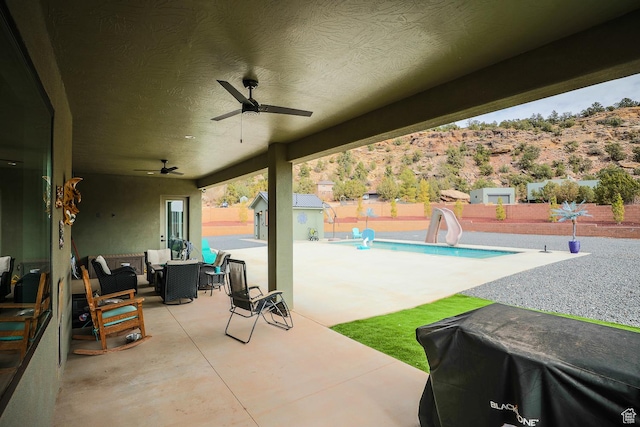 2906 N Purple Sage Rd, Apple Valley, UT 84737 - view of patio / terrace featuring a fenced backyard, a ceiling fan, an outdoor hangout area, an outdoor structure, and a shed