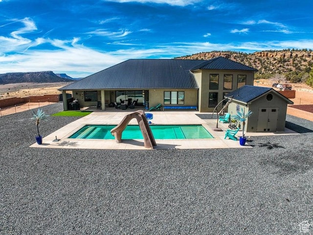 2906 N Purple Sage Rd, Apple Valley, UT 84737 - outdoor pool with a mountain view, a patio area, a storage shed, and an outbuilding