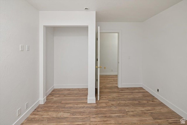 empty room featuring wood finished floors and baseboards