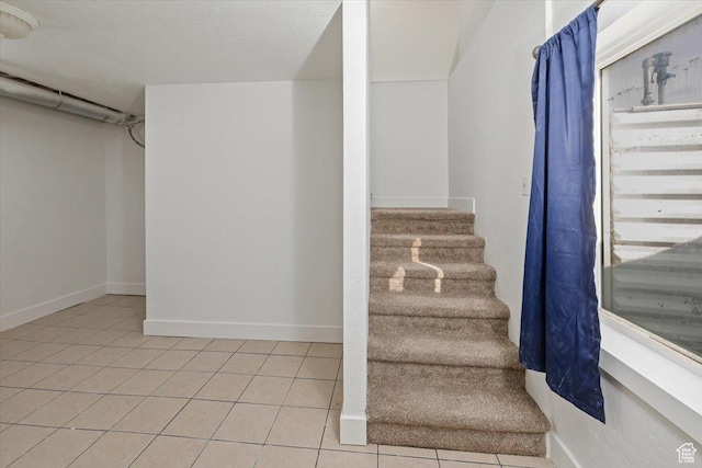 stairway with tile patterned flooring and baseboards