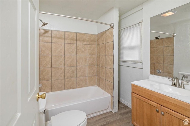 bathroom featuring vanity, bathing tub / shower combination, toilet, and wood finished floors