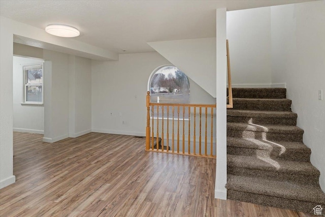 stairway featuring baseboards and wood finished floors