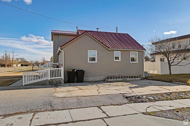 rear view of house featuring metal roof, a patio area, and fence