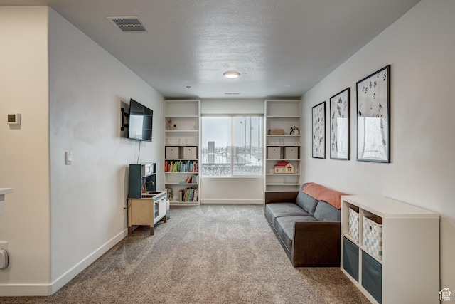 sitting room featuring baseboards, a textured ceiling, carpet, and visible vents